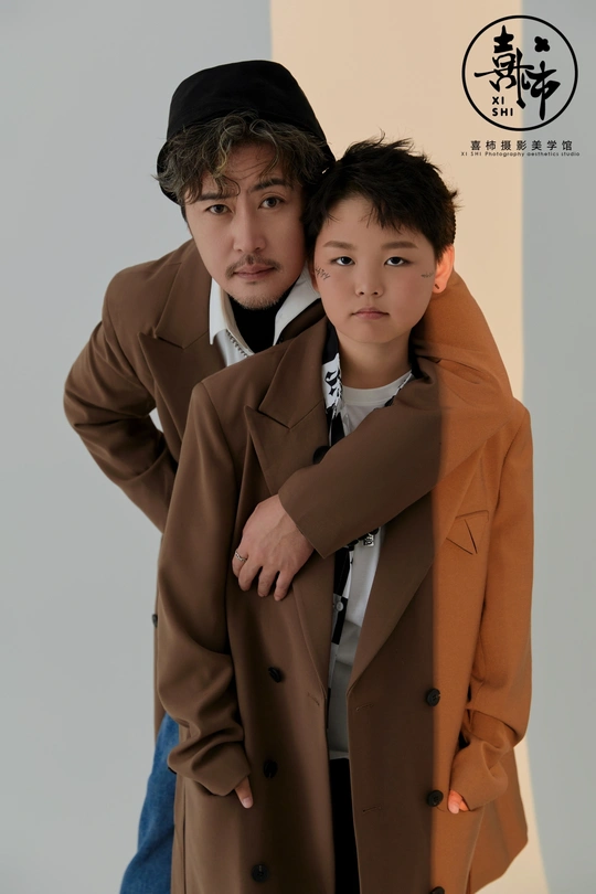 一个穿着外套的年轻男孩紧紧地搂着一位穿着西装的男人的肩膀