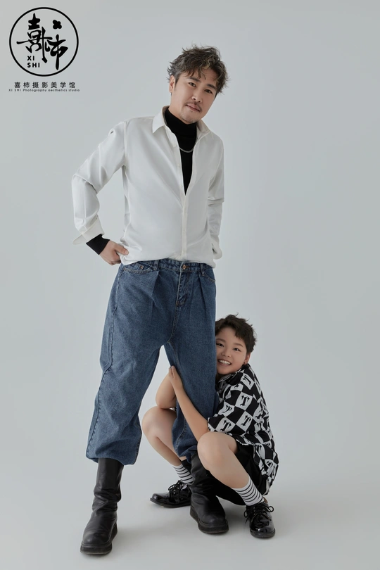 一个穿着白衬衫的年轻人与一个小男孩合影