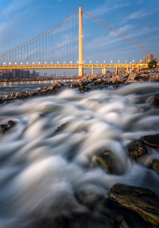 河上有岩石和桥作为背景