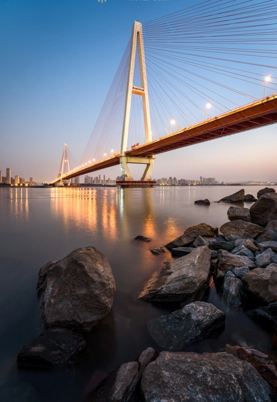 河上有一座长桥 桥上岩石 背景是一座新城。