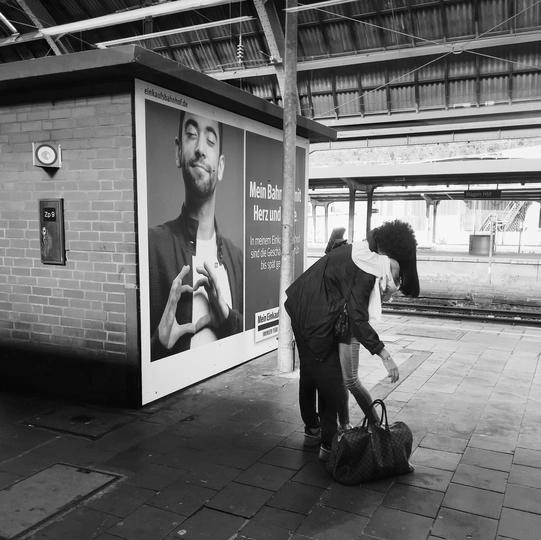 一张黑白照片 一个带着行李的男人在火车站 一张火车上的男人的海报