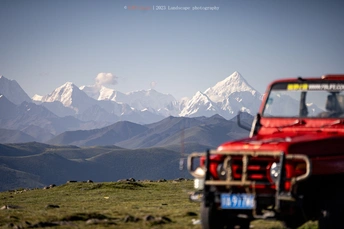 一辆红色的卡车停在山路上的路边