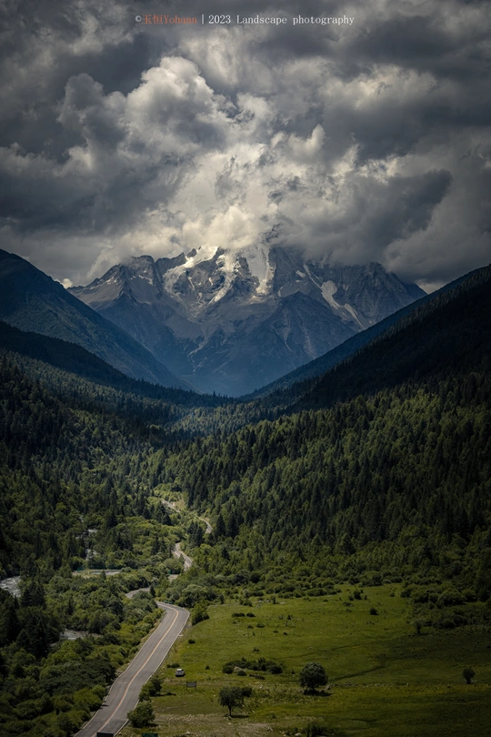 一个山谷 有道路、山脉、森林和一条河流。