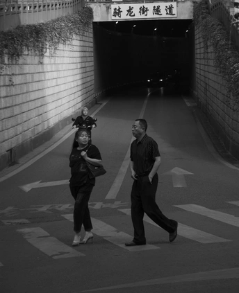 一个人和一个女人正在走下一条街道 这条街道旁边有一个隧道。