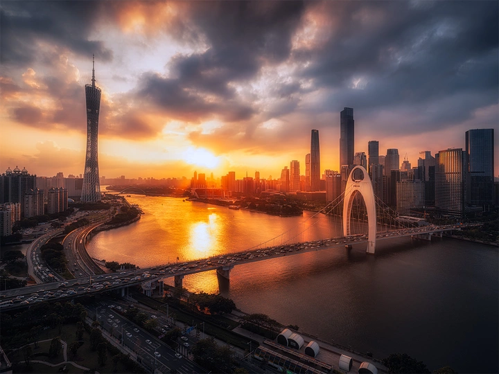 夕阳下的城市 高耸的建筑物和横跨河流的桥。