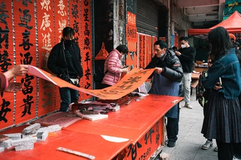 一位站在街边 旁边是红色桌子的一名妇女