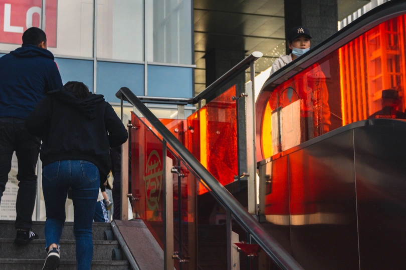 一个男子和一个女子走在一栋建筑附近的一些楼梯上。