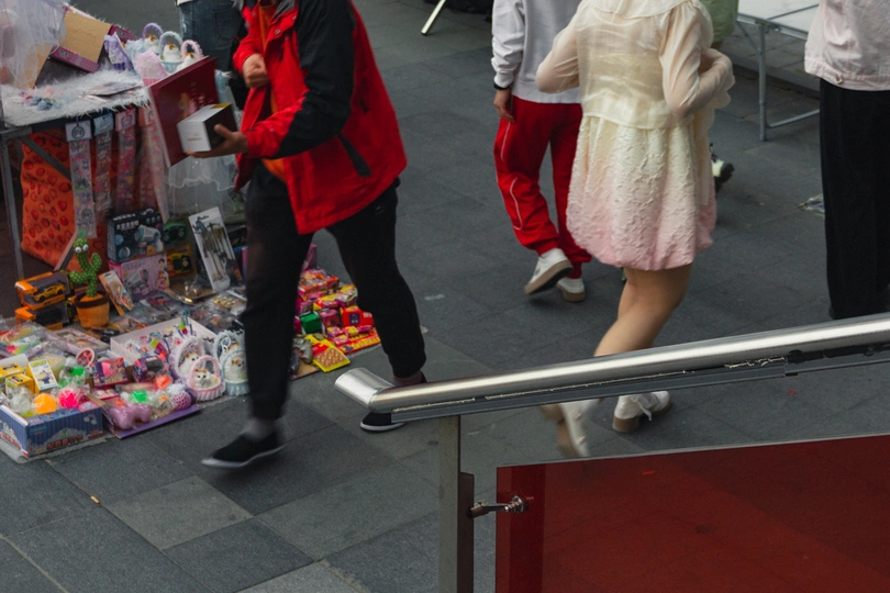 一位女士走在街上 手里拿着一把雨伞