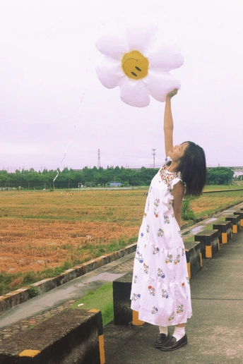 一个小女孩穿着白色裙子拿着花