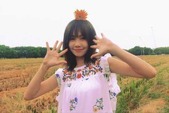 一位妇女站在田野中 双手举过头顶