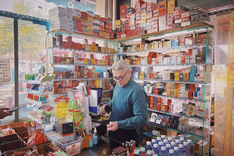 一位年长的妇女站在一家商店里 正在看药品。