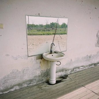 一个带有白色墙壁和洗脸盆上的镜子的浴室