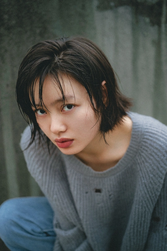 一个穿着蓝色毛衣的年轻女子坐在椅子上