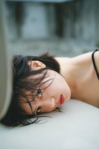 一个穿黑色衣服的年轻女子躺在白色床上