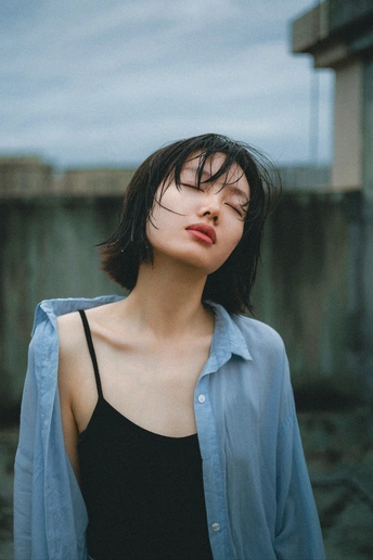 一位年轻女性黑发站立在外面的肖像