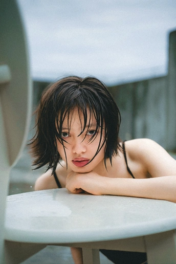 一个金发年轻女子 桌子上放着一块白板冲浪板。