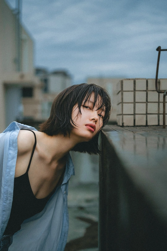 一个年轻人靠在屋顶上俯视屋顶上的女人 她有着蓝色的眼睛。