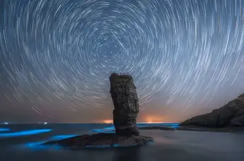 夜晚海中的岩石 天空中繁星闪烁