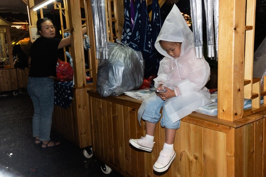一个小女孩穿着雨衣坐在木制火车上