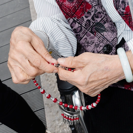 一个拿着带红珠子的项链的老妇人