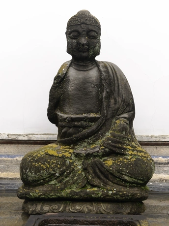 一尊作者坐着的青铜雕像 底座为石头