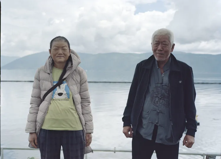 一位老夫妇站在一艘船上的水域旁