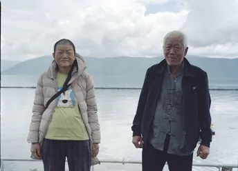 一位老夫妇站在一艘船上的水域旁