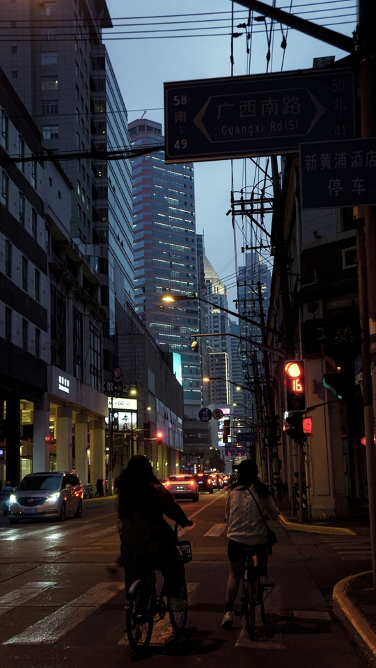 夜晚的城市街道 人们骑自行车和汽车在街上行驶。