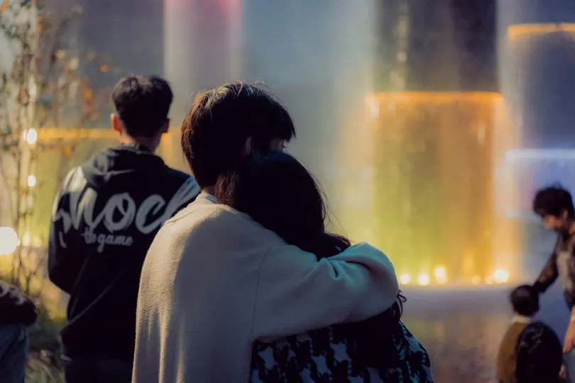 人们坐在喷泉前 人们注视着水。