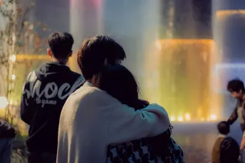 人们坐在喷泉前 人们注视着水。