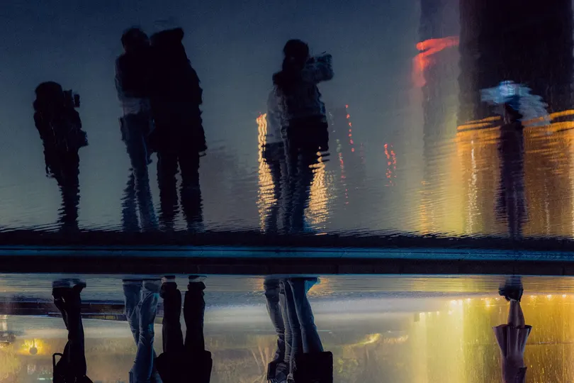 夜晚城市的倒影 人们手持伞站立