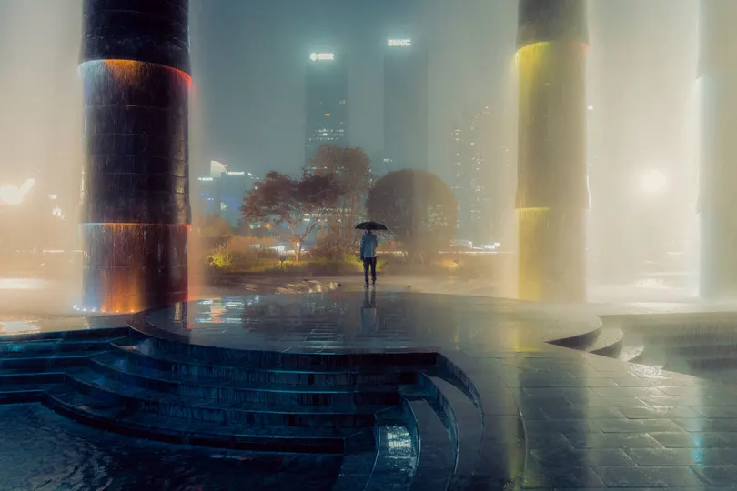 在一个雾蒙蒙的夜晚 一个雾蒙蒙的城市 有一座带有柱子和石柱的塔 被水照亮了。