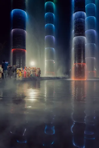 夜晚 水龙头亮着 前景有人。