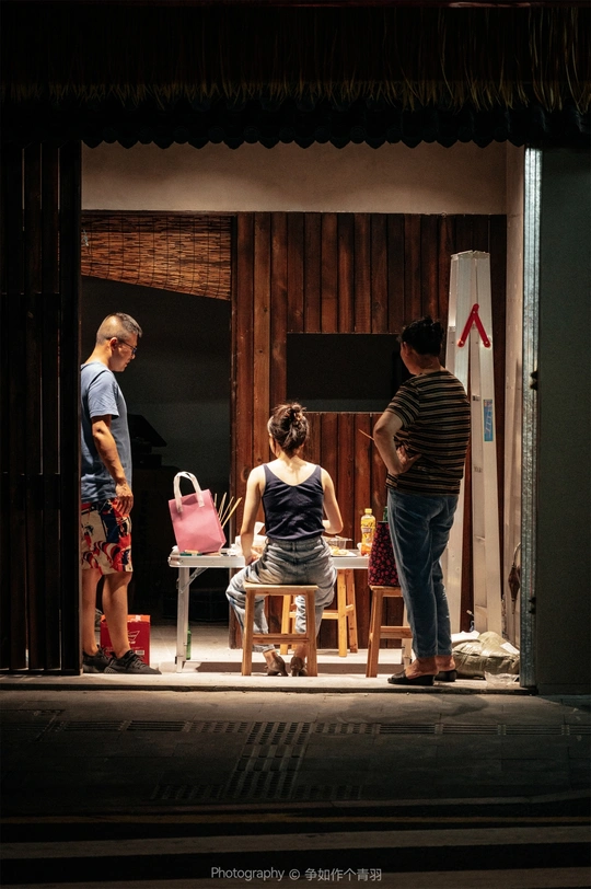 一个戏剧场景 一个男人和一个女人站在舞台上 一个女孩站在一把椅子上。