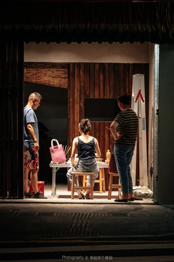 一个戏剧场景 一个男人和一个女人站在舞台上 一个女孩站在一把椅子上。