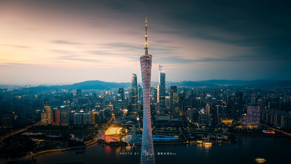 夜幕下的城市照片 有高塔和其他建筑在天线上。