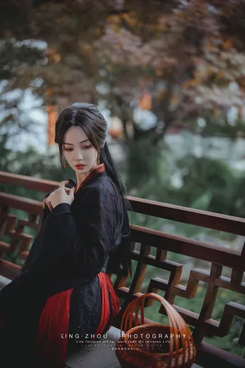 一个穿着黑色连衣裙的女人坐在长凳上