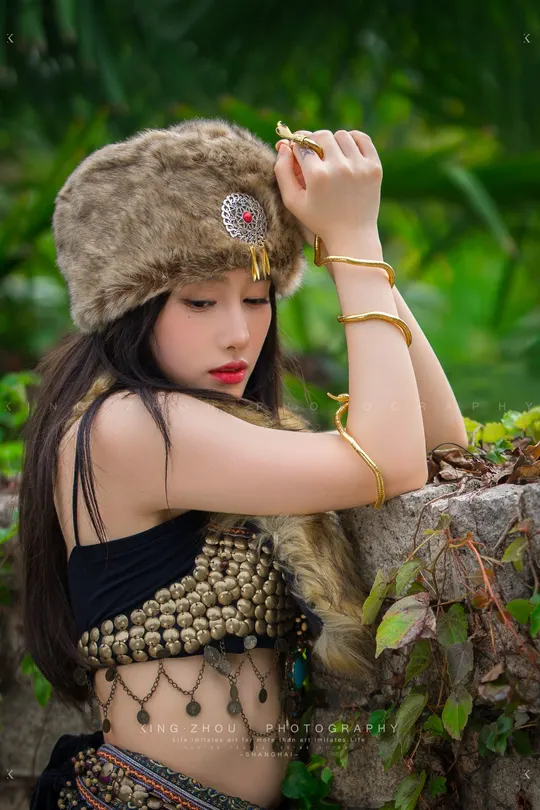 一位身着传统服装的年轻女子在丛林中摆姿势