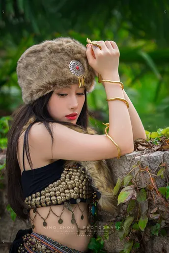 一位身着传统服装的年轻女子在丛林中摆姿势