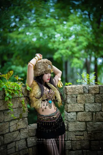 一位身着服装的女性靠近石头墙