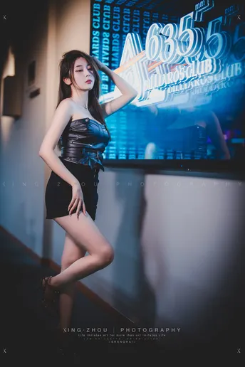站在投影屏幕前的穿黑色连衣裙的年轻女子