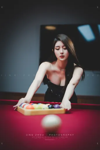 一位年轻女子在红色桌子上打台球