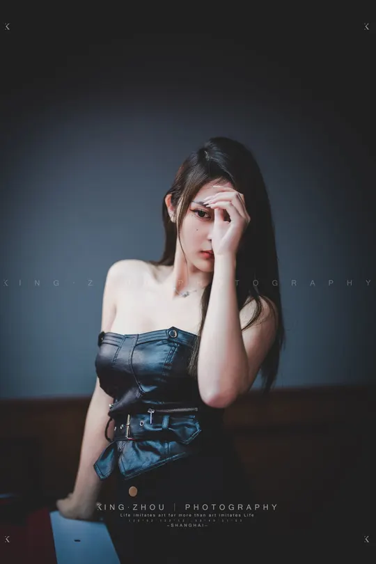 一位穿着黑色连衣裙的女性举手示意。