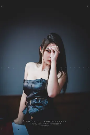 一位穿着黑色连衣裙的女性举手示意。