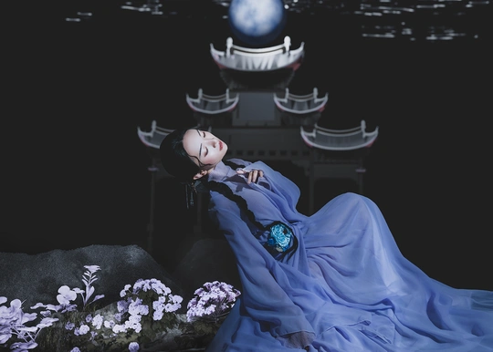 一个穿着带花和水的蓝色连衣裙的女人