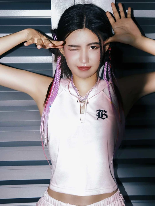 一位年轻的亚洲女孩在窗帘前摆姿势