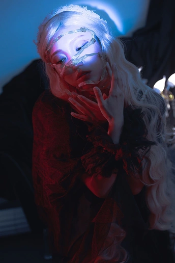 一个戴着手套的3D女人在一个黑暗的房间里 她的脸上有一束蓝色的光。