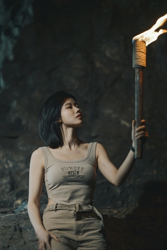 一位年轻女子手持燃烧的火炬 