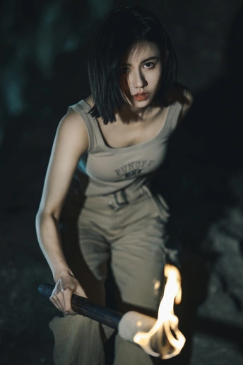 一个人手里拿着一支喷出火焰的枪在黑暗中