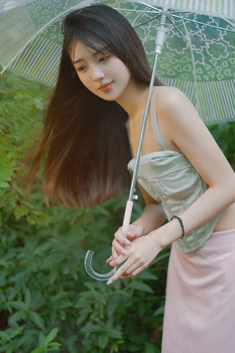一位年轻女子手持雨伞在外拍照